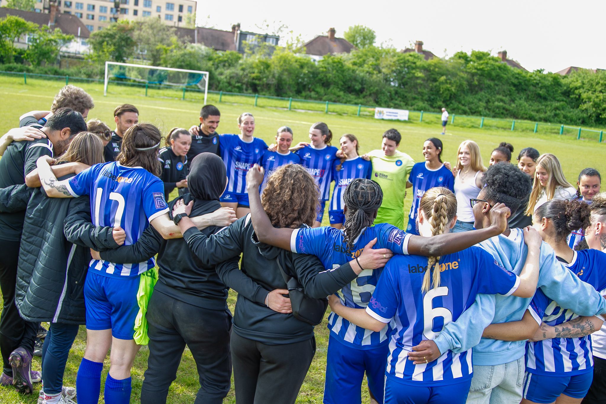 Players and coaches in a team huddle after a match